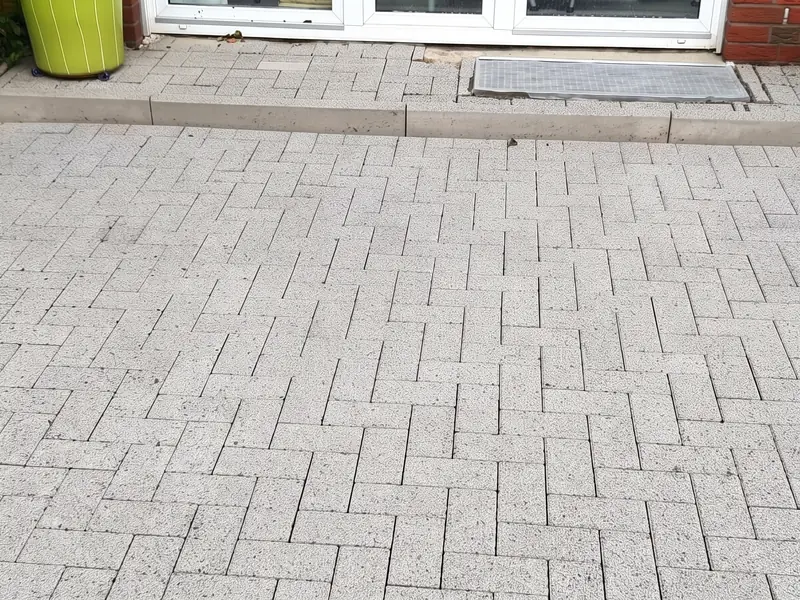 Dieselbe Betonpflaster-Terrasse nach der Reinigung, Stein wieder hell